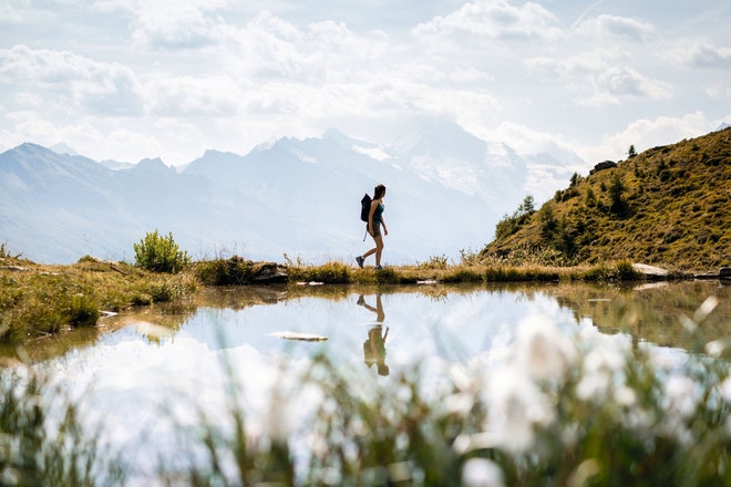 Eine Wanderin am Ufer eines kleinen Bergsees in der Schweiz