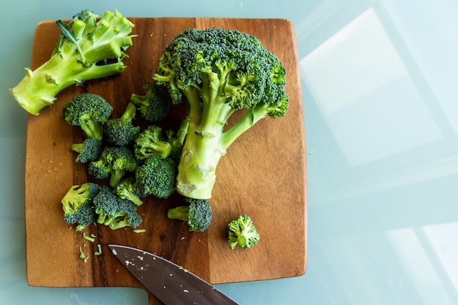 Ein Broccoli auf einem Brettchen, klein geschnitten