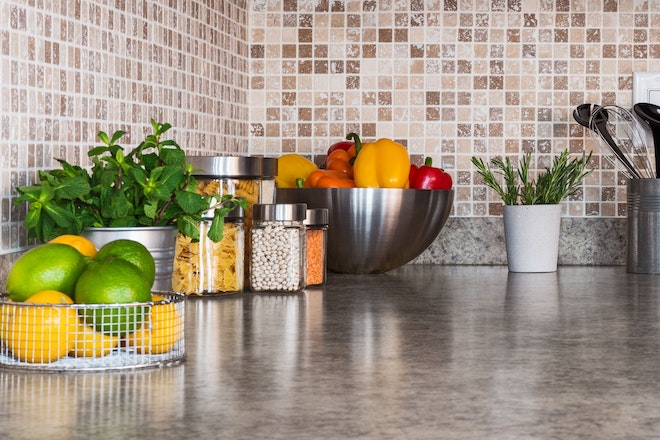 Eine Küche mit Schüsseln mit Gemüse, Kochutensilien und Mosaik-Fliesen