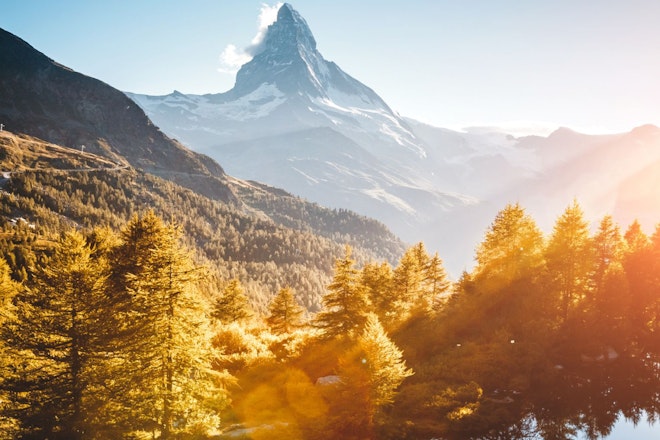 Das Matterhorn, ein hohes, spitzes Gebirge hinter einem Hügel und Gewässer