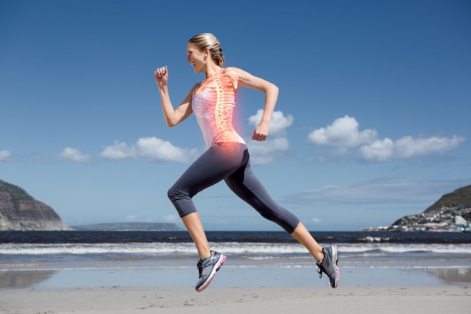 Fröhliche Frau in rennender Position mit leuchtender Wirbelsäule und Meer im Hintergrund