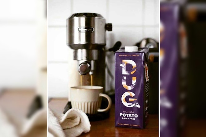 Die DUG Milk Barista Edition neben einer Kaffeemaschine, aus der Kaffee in eine Tasse läuft