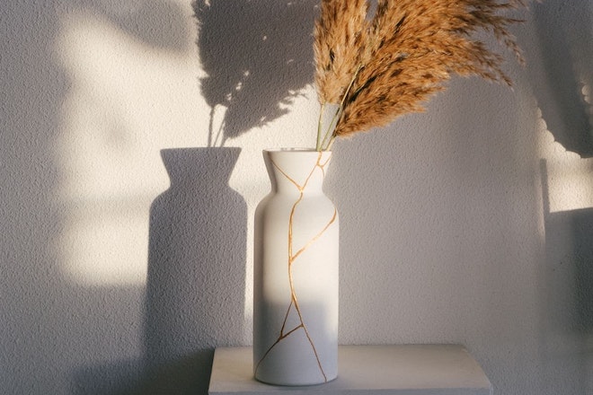 Eine weisse Vase mit Rissen, die vergoldet sind