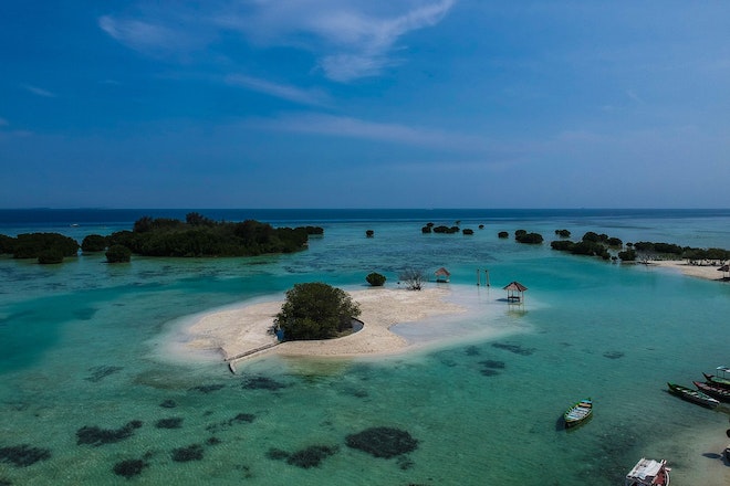 Blick auf Teile der indonesischen Insel Pari mit Booten am Strand