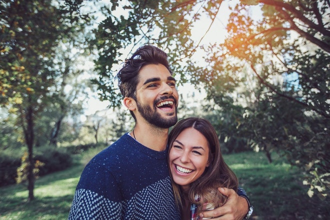 Ein junges, lachendes Paar in der Natur