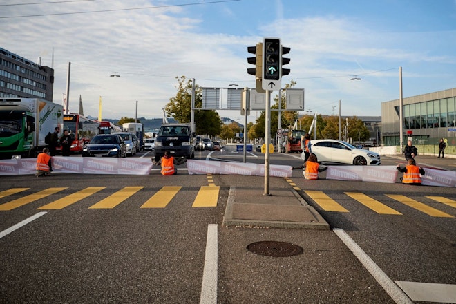 Sechs Demonstrierende von Renovate Switzerland blockieren eine Kreuzung