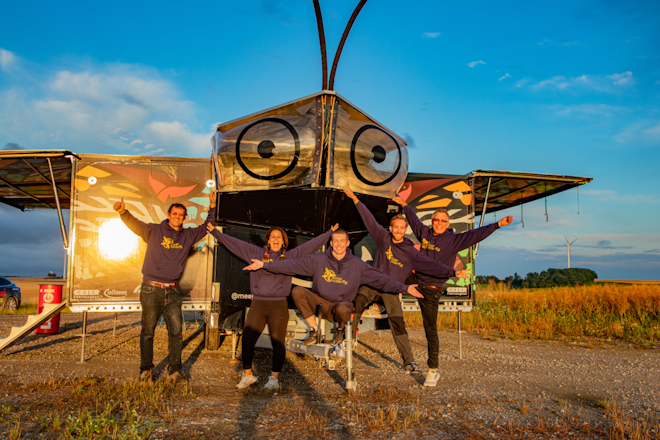Louis Palmer und vier seiner Teamkollegen posieren in der Abendsonne vor dem SolarButterfly und haben Spass