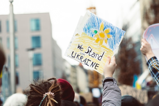 Friedensdemonstration, ein Schild mit Aufschrift «We Stand with Ukraine» wird hochgehoben