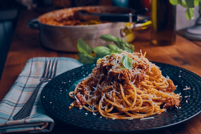 Schwarzer Teller mit Spagetti und Bolognese Sauce