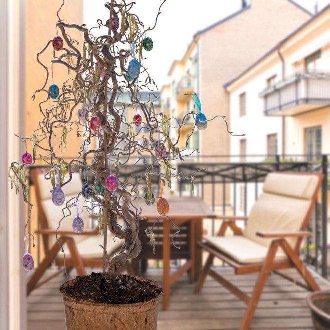 ein bunt dekorierter Osterbaum steht auf einem Balkon