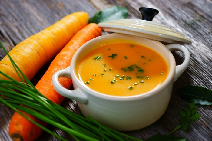 eine orangene Suppe mit Rüebli nebendran