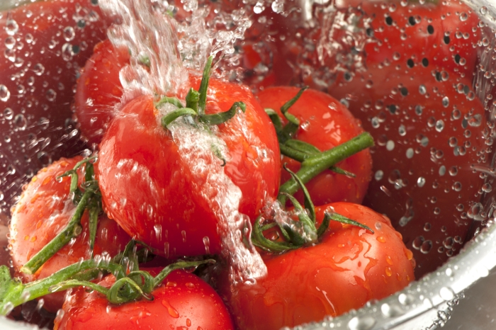 Wasser spritzt um Tomaten herum