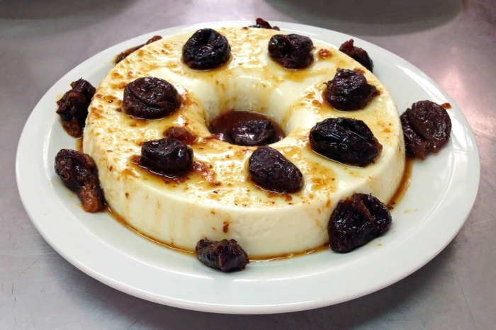 Ein Pudding in Dounat-Form mit einzelnen gekochten Pflaumen drauf
