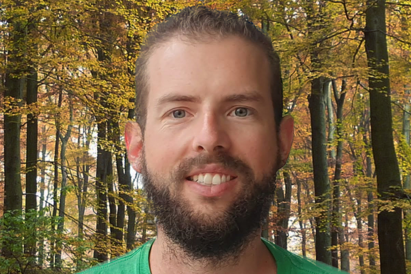 ein Mann mit braunen Haaren, Bart und einem grünen T-Shirt