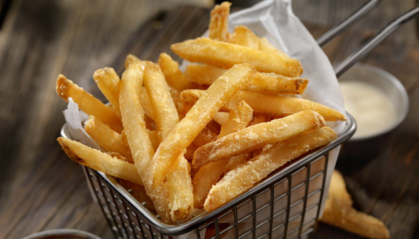 knusprig aussehende Pommes in einem Frittier-Gitterchen