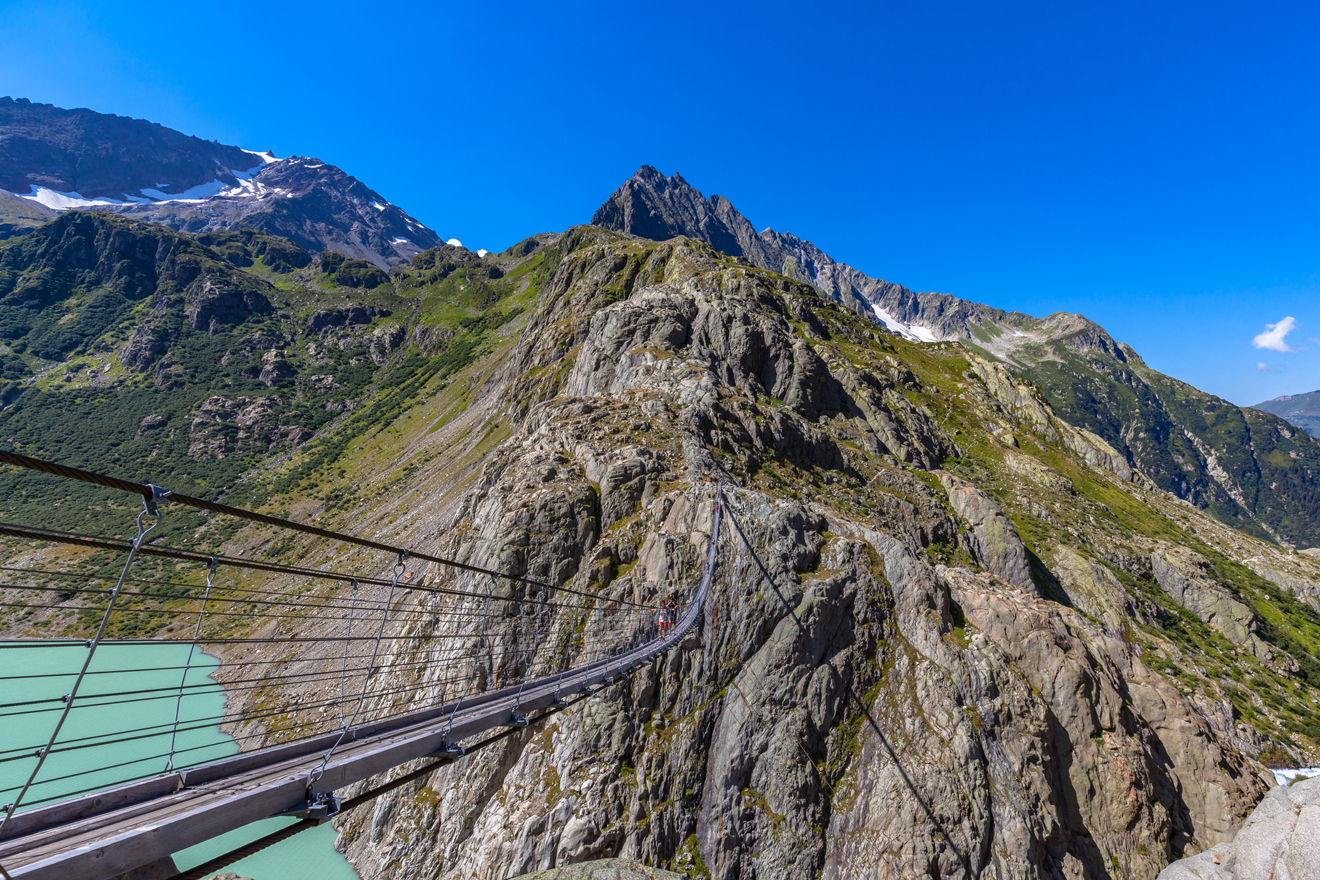 Hängebrücke mitten im Bergkessel mit Bergsee unten 