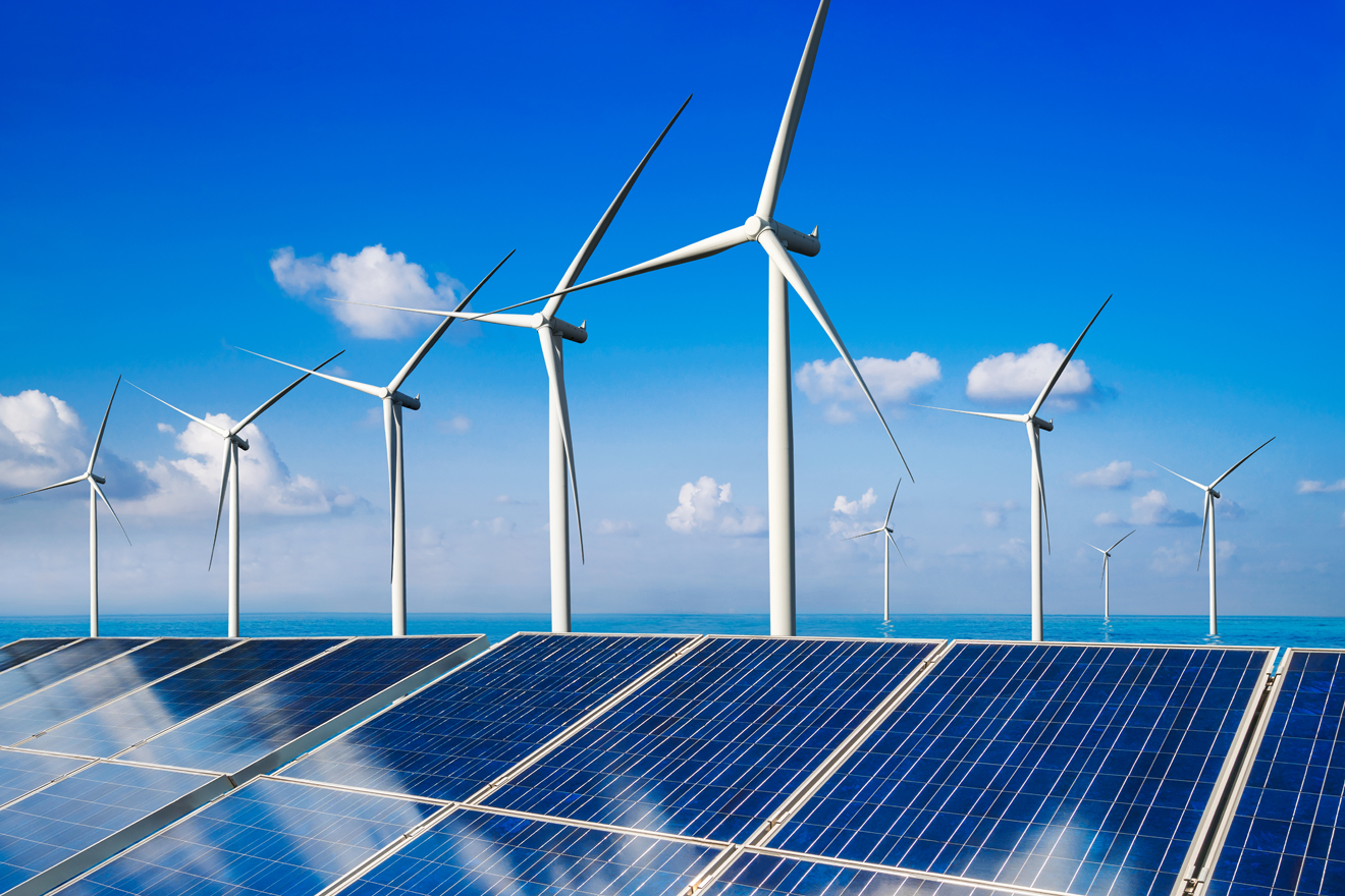Anlage mit Solarpanels – hinten dran Windkraftanlagen