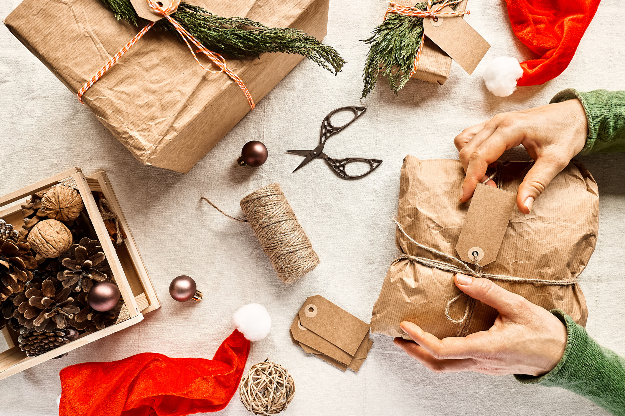 Zu sehen sind Geschenke, Geschenkpapier und andere nachhaltige Materialien zur weihnachtlichen Verpackung von Geschenken